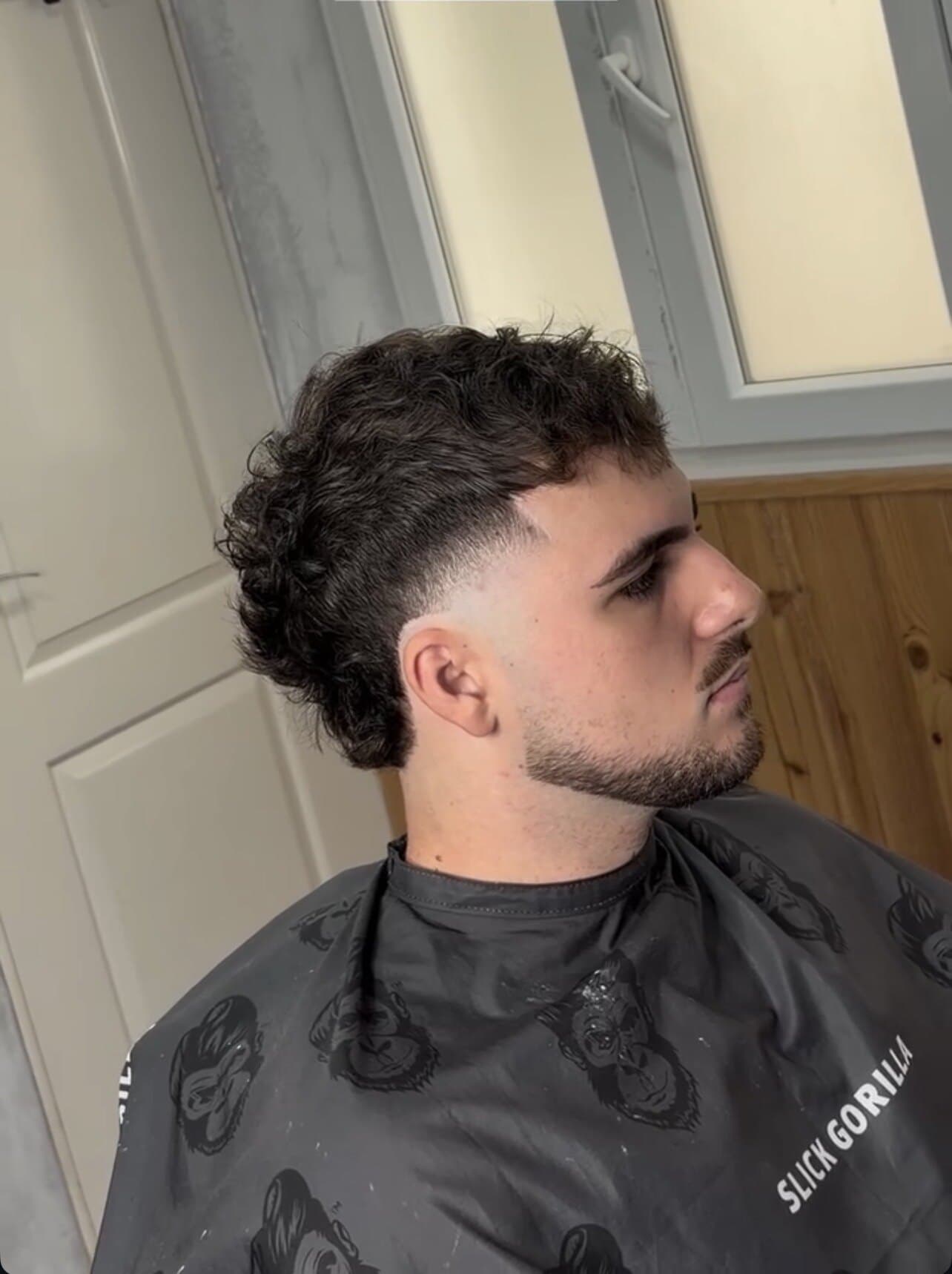 Mullet rizado con fade y barba